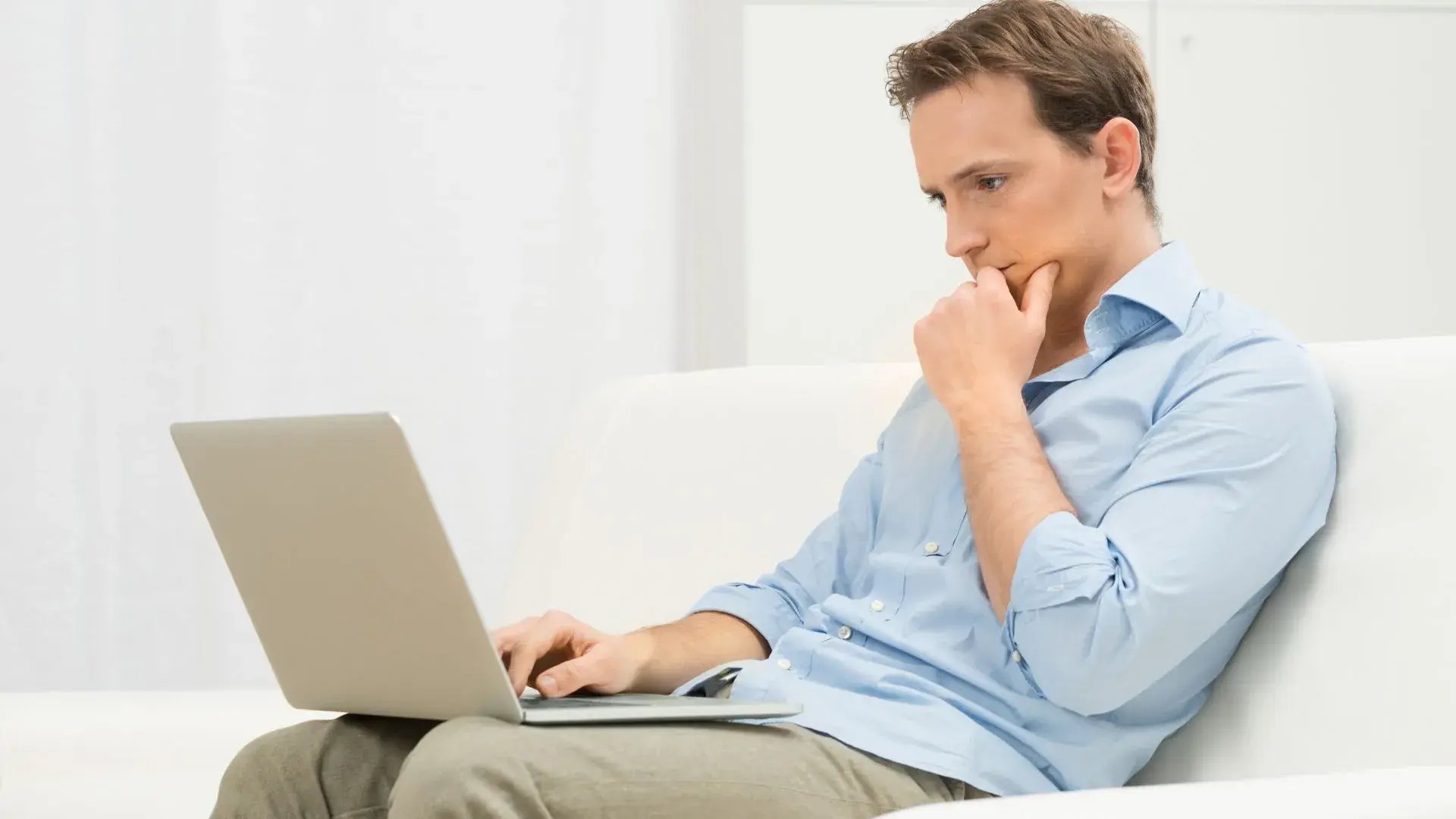 A man in deep thought while using their laptop