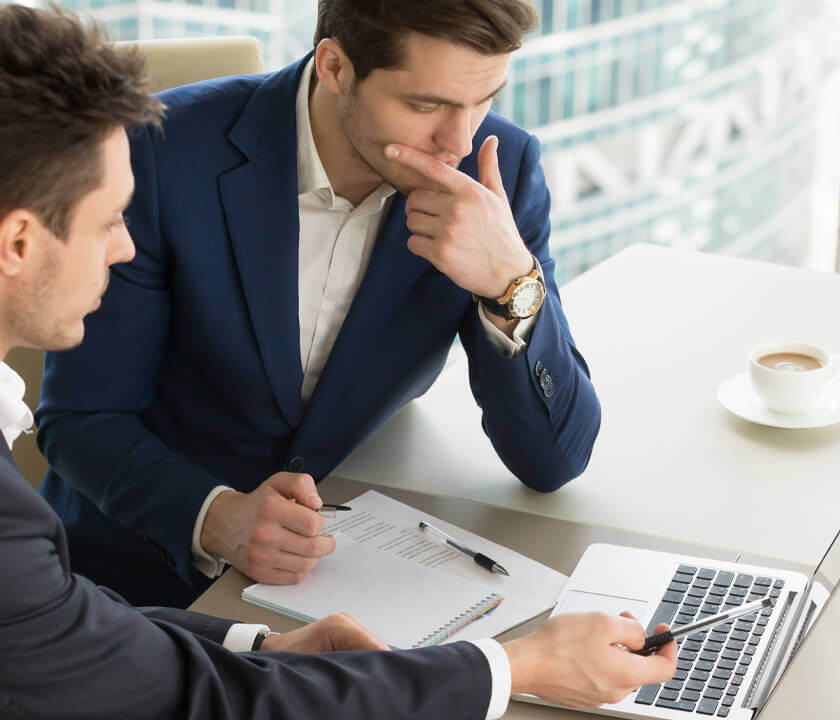 Two men in suits reviewing Jericho's training offerings in cybersecurity for tech companies