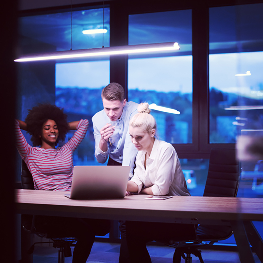 Employees at small tech startup using laptop to train on cybersecurity for tech companies