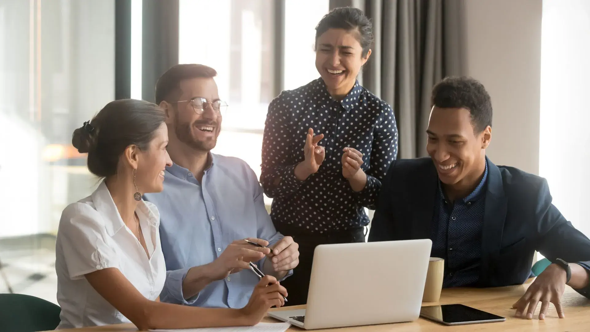 A group of corporate employees laughing at a phishing email