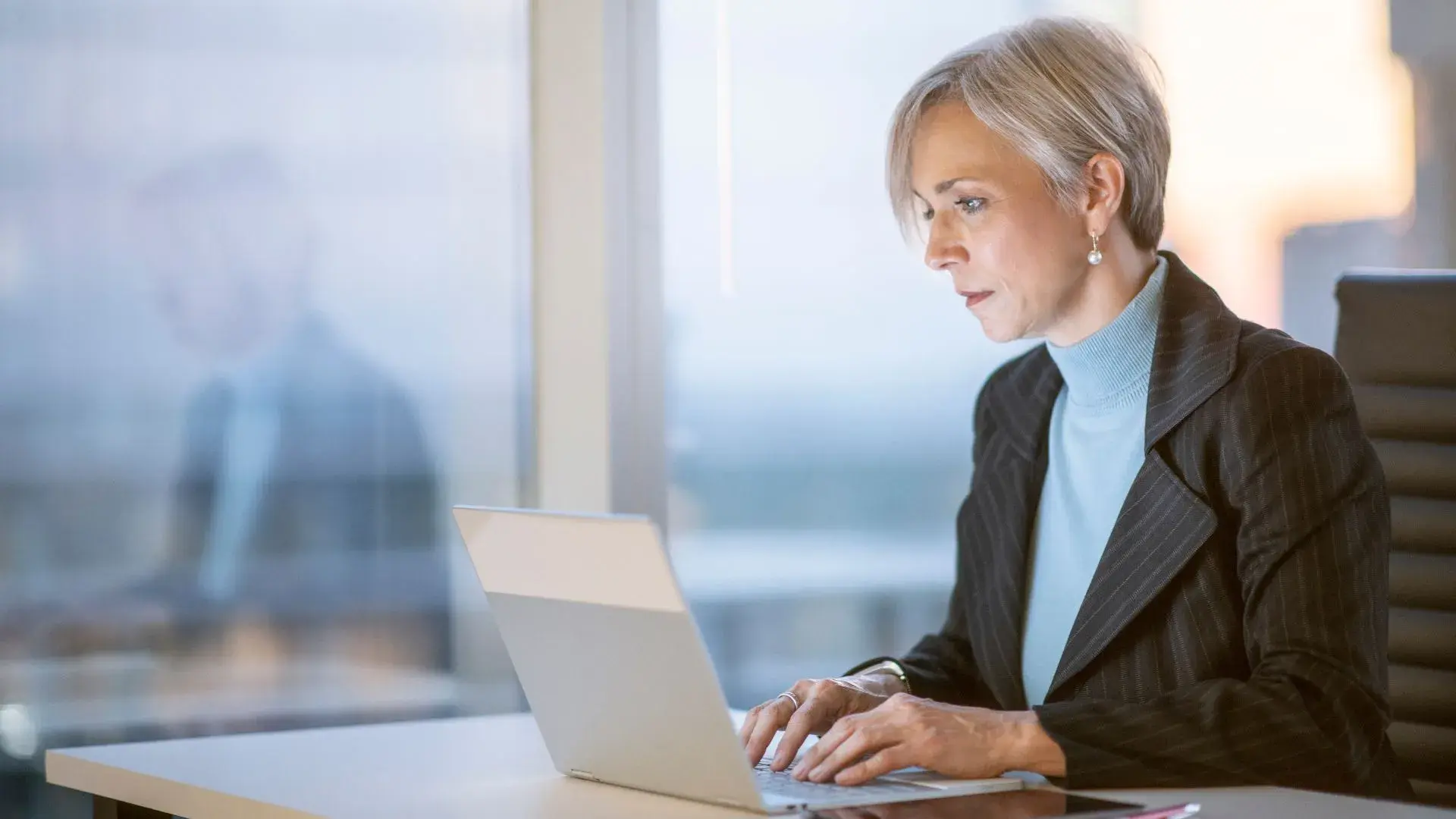A woman dressed in corporate attire perusing her email presumably stumbling upon some phishing attempts 